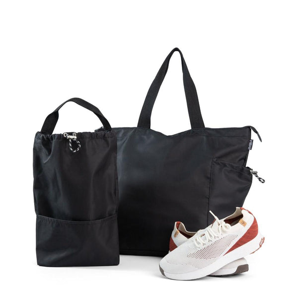 Large black bag with Large black tote beside a pair of white sneakers
