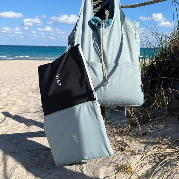 wet and dry bag hanging with misty blue bag at the beach