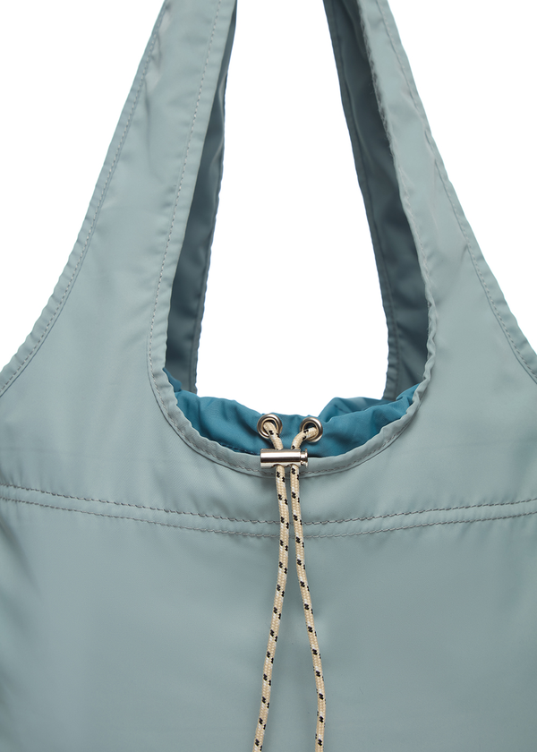White draw string of misty blue bag