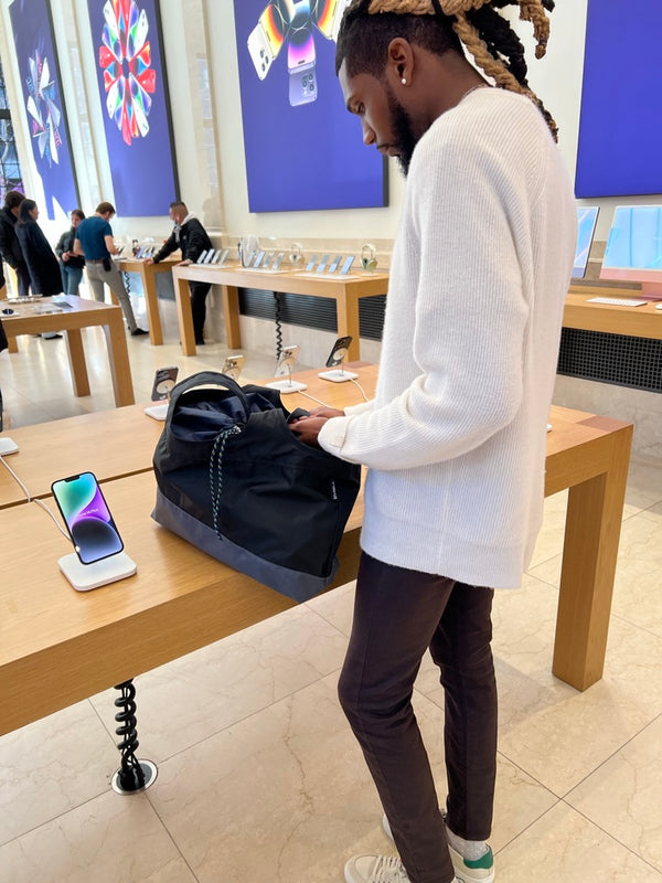 Person in an electronics store with the black bag on a table