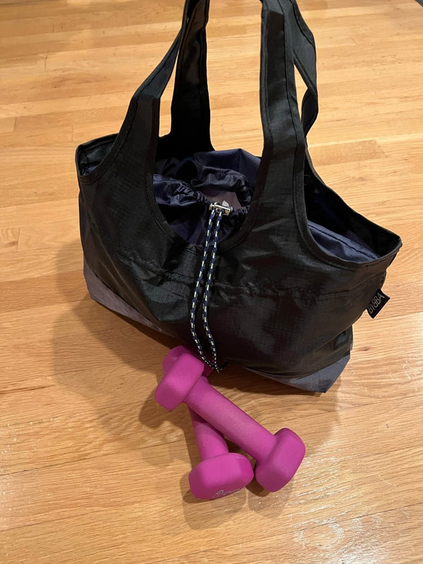 black bag on the floor next to pink weights