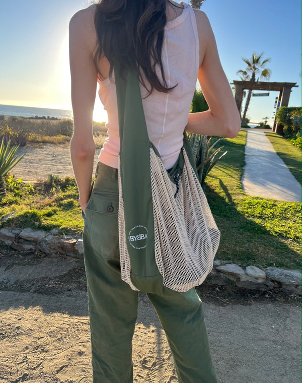 person wearing net bag cross body and at hip while outside