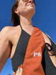 view of rust strap across a woman's chest while outside