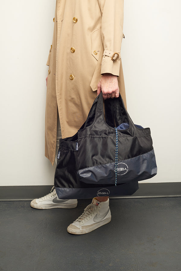 man holding black bag by their side