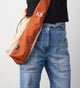 net bag with rust straps worn cross body and at the hip