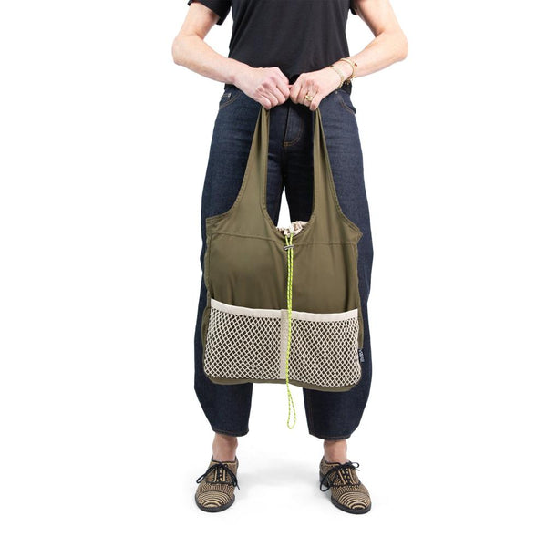 person holding seaweed bag with front mesh pocket hanging at their knees