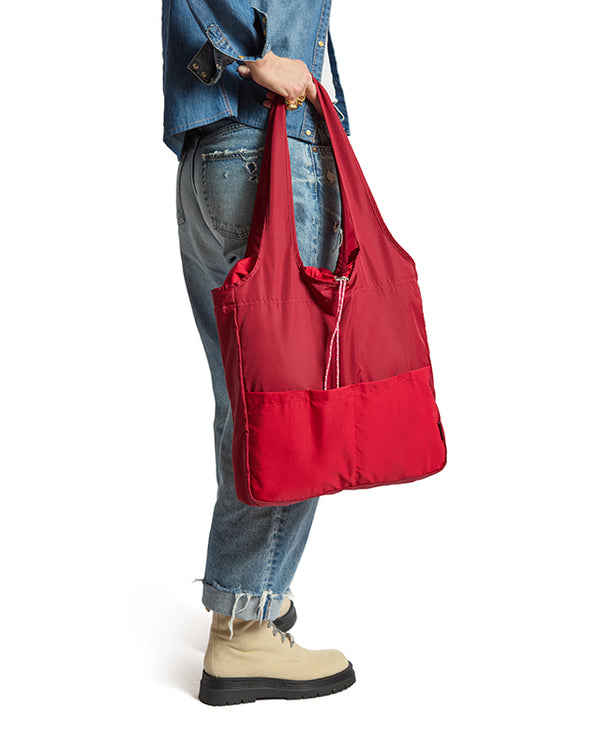 person holding rich red bag at their side