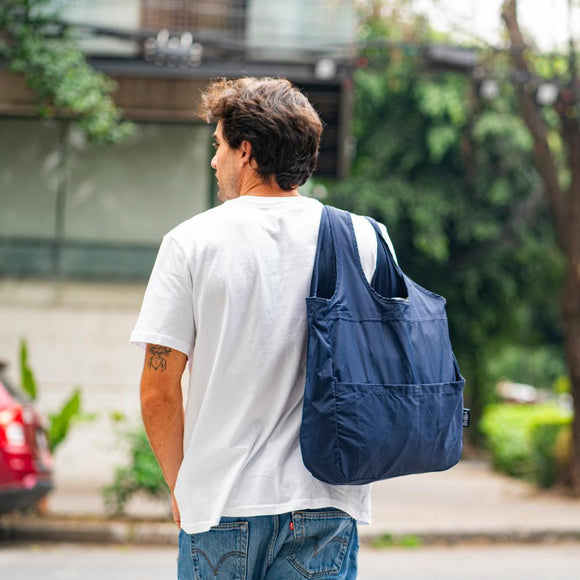 man holding navy bag over his shoulder