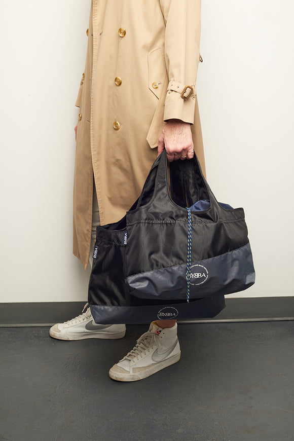 man holding black bag by their side 